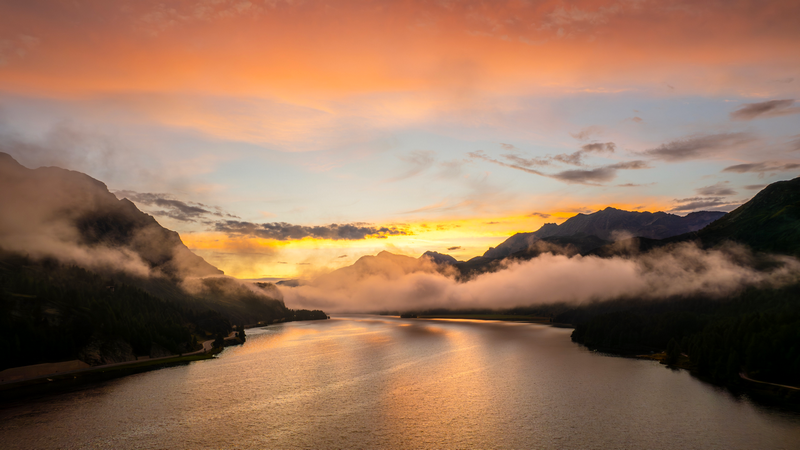 Misty mountain lake at sunrise with colorful sky