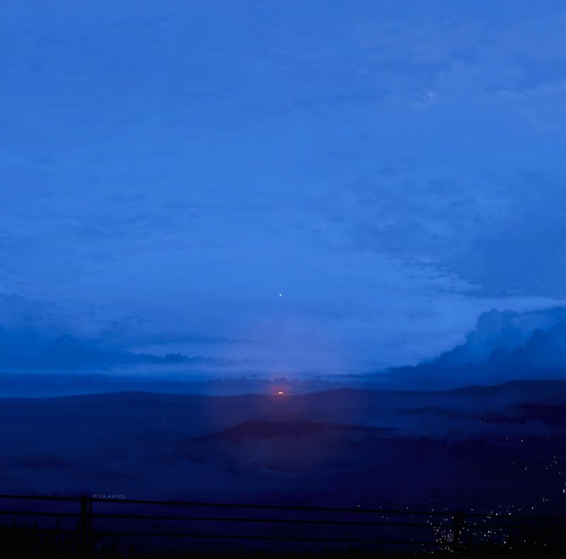 Scenery of a blue sky with clouds over a misty landscape