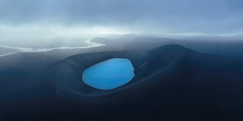 Blue lake in a dark volcanic crater in Iceland