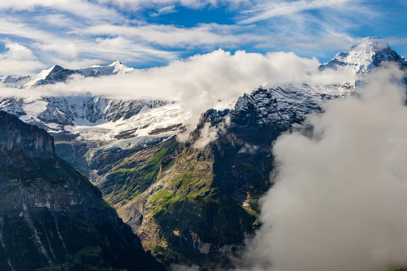 Snow-capped mountains with clouds and cliffs