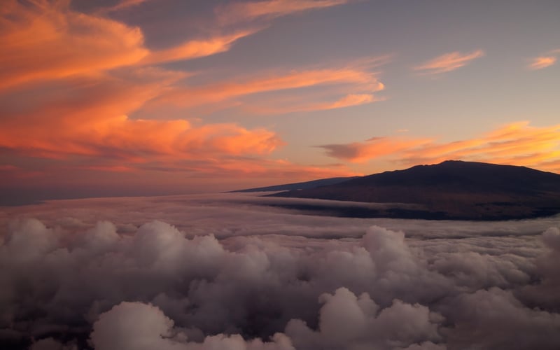 Sunset over clouds with Hawaiian mountains