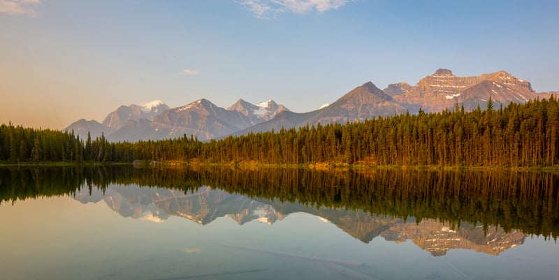 Mountain Range Reflected in a Calm Lake with Pine Trees