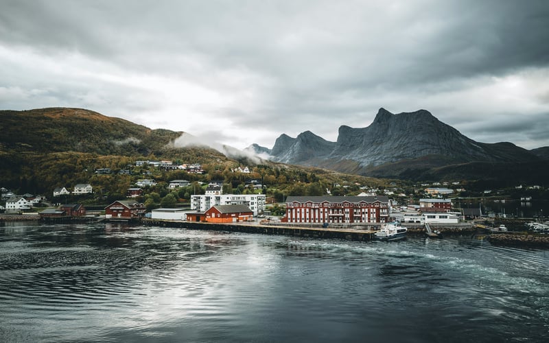 Coastal town nestled at the foot of misty mountains