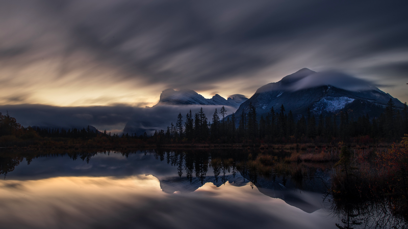 Mountains reflected in a lake under cloudy sky