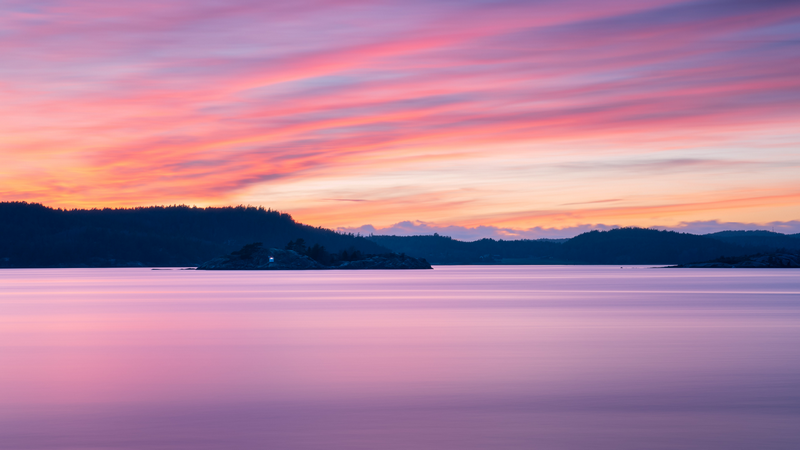 Pink clouds over a calm lake at sunset