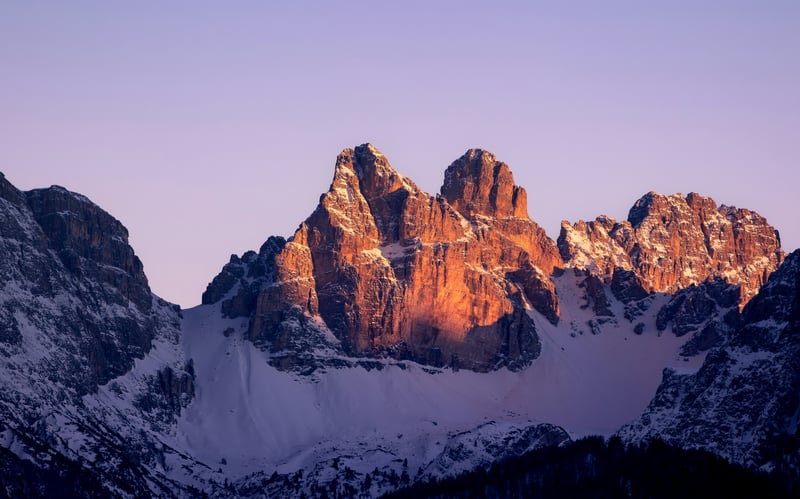 Snow-covered mountains bathed in golden sunlight