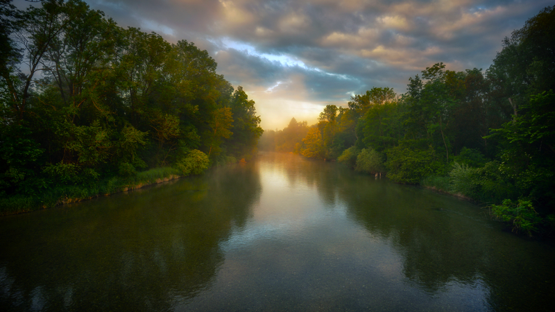 River flowing through a forest at sunrise