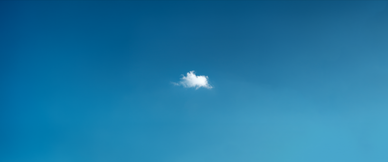 A single white cloud in a clear blue sky