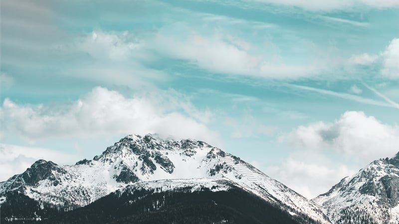 Snow covered mountains under a cloudy sky