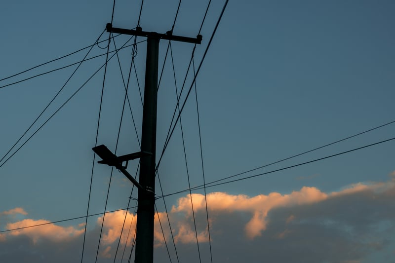 Silhouette of a utility pole against a twilight sky