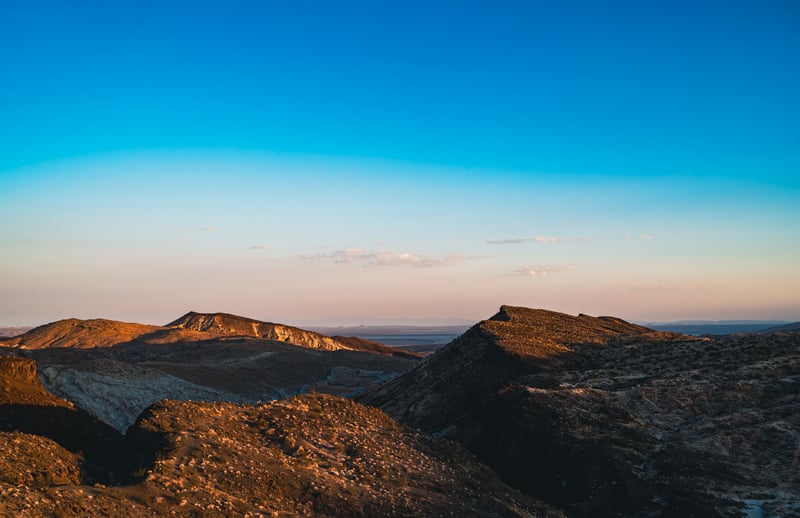 Desert mountains under a clear blue sky at sunset