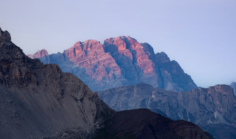 Sunlight illuminates rugged mountain peaks at dawn