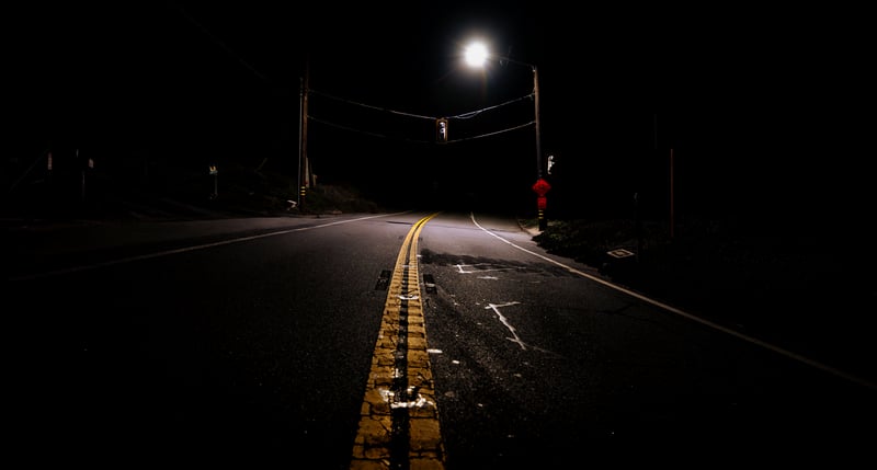 Empty road at night with streetlights