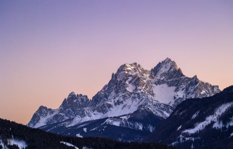 Snow-capped mountains under a clear sky at sunset