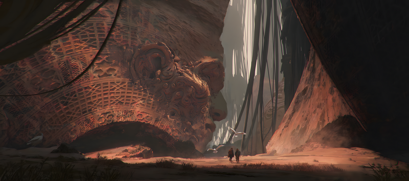 Two men walk past a giant carved stone head in a canyon