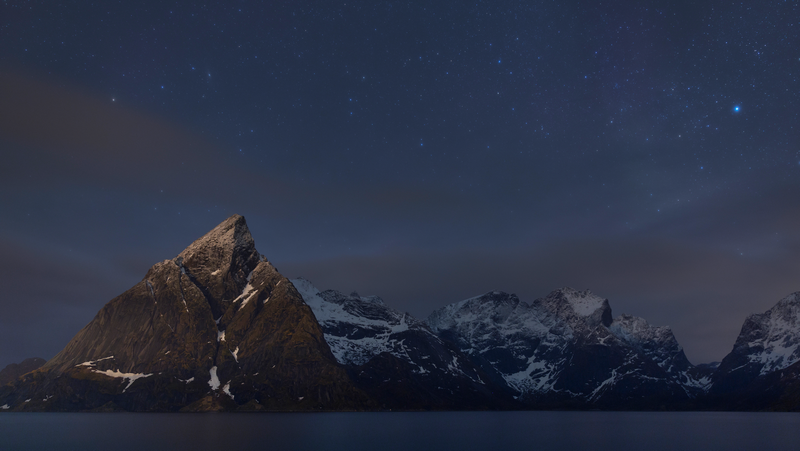 Snow-capped mountains under a starry night sky