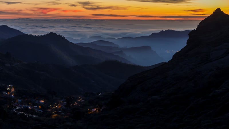 Mountain landscape with clouds and village at dusk