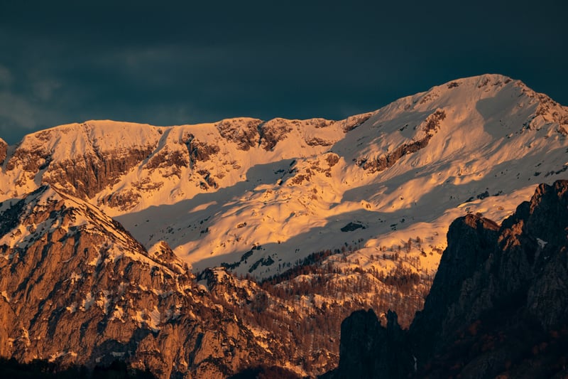 Snowy mountain peaks illuminated by sunset glow