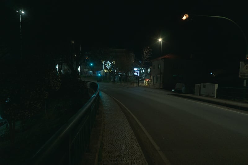 Empty street at night with streetlights and sidewalks