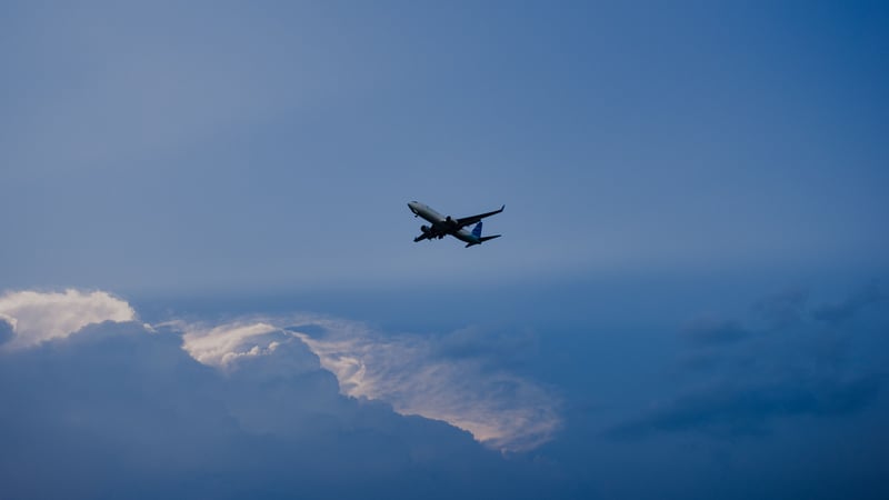 Airplane flying in a blue sky with clouds