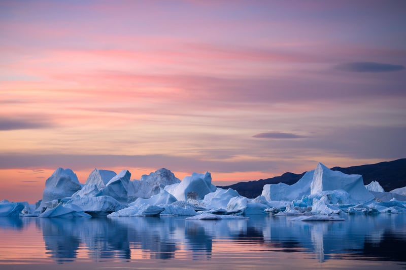 Icebergs floating in water during sunset in Greenland