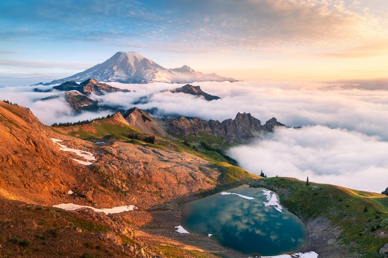 Mount Rainier above clouds with alpine lake reflection