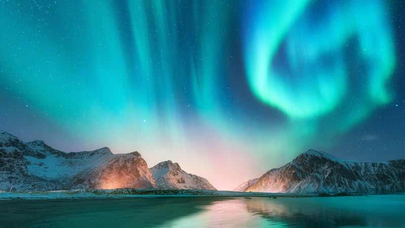 Aurora Borealis over snowy mountains and water