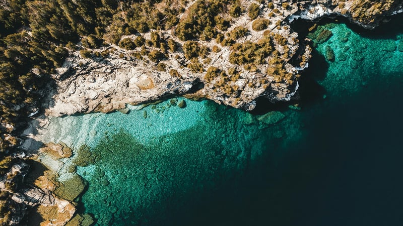 Aerial view of rocky coastline and clear turquoise sea