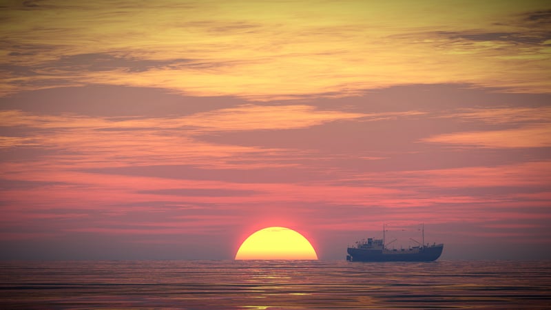 Ship sailing on the ocean during a vibrant sunset