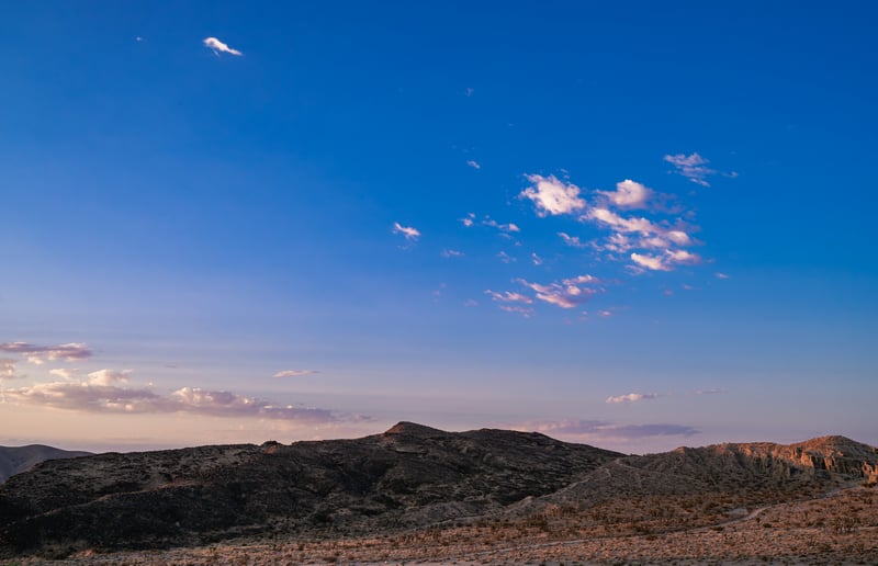Desert landscape with mountains and clouds at sunset