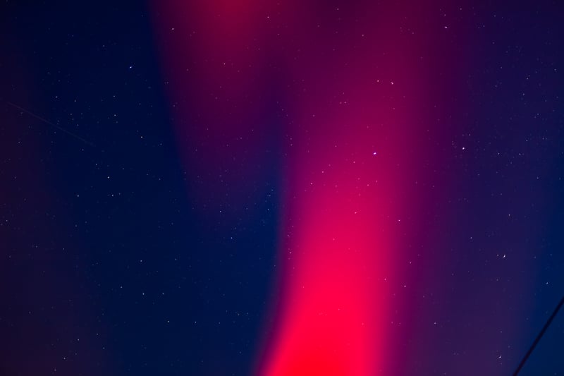 Red aurora borealis in a starry night sky
