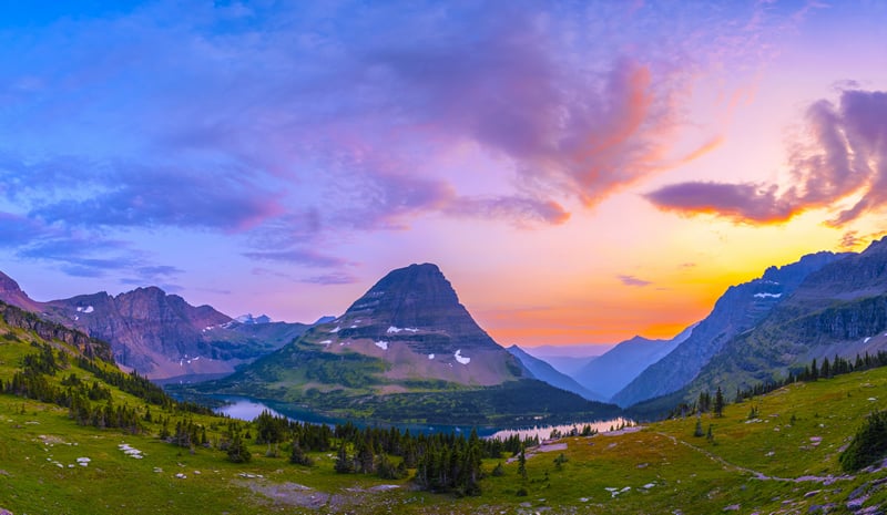 Sunset over mountains with lake and trees