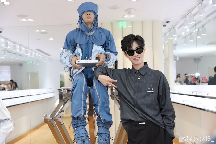 Song Ji Yang poses with a mannequin in a blue outfit