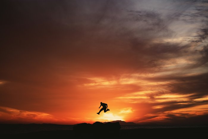 Silhouette of a man jumping at sunset