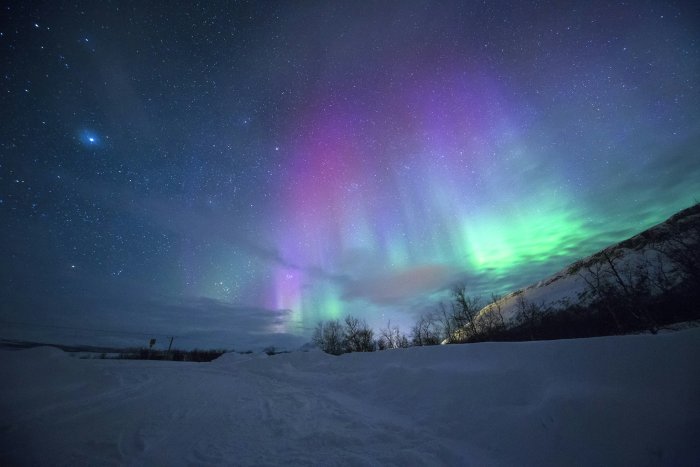Northern Lights over a snowy landscape in Norway