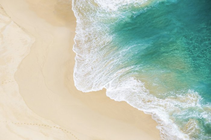 Aerial View of Turquoise Ocean Waves on Sandy Beach