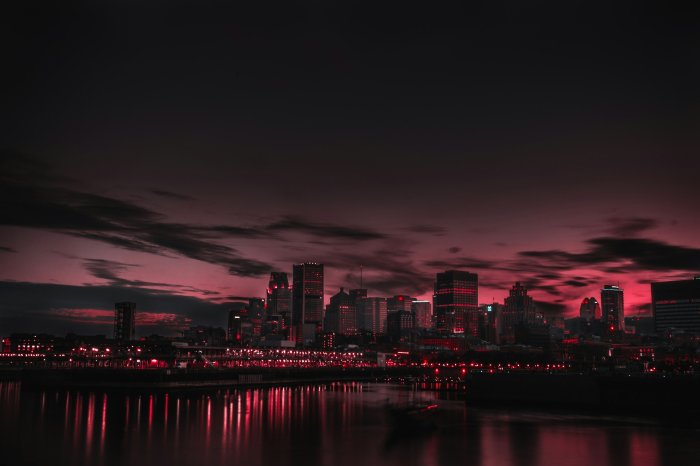 Red city skyline at night with water reflections