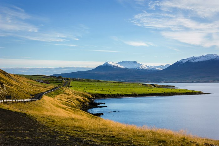 Scenic coastal road and snow-capped mountains in Iceland