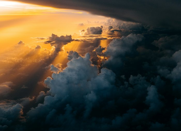 Sunset light breaking through dark storm clouds