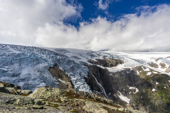 Glacier flowing down a rocky mountain cliff