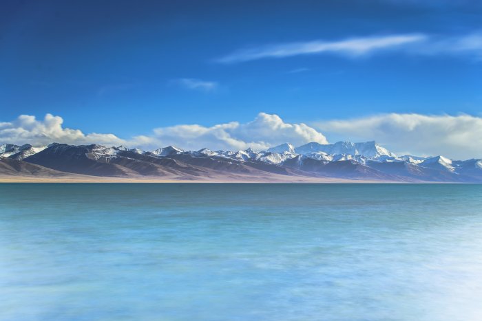 Snowy mountain range behind a calm blue lake
