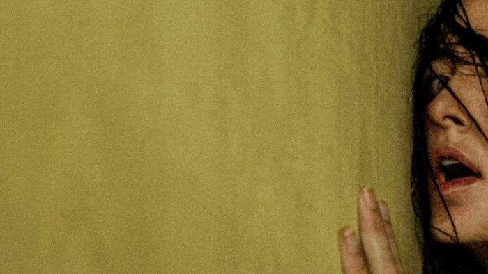 Frightened woman against yellow wallpaper in Backrooms