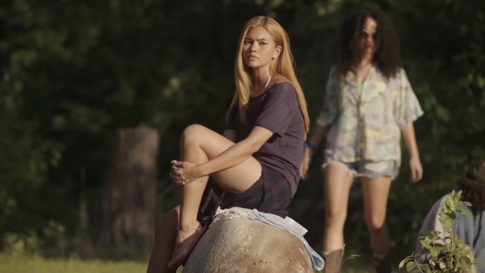 Blonde woman sitting on a rock in Girls Like Girls