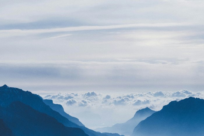 Blue mountain silhouettes with a sea of clouds