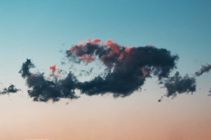 Dark cloud with pink highlights in a gradient sky