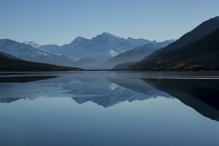 Snowy mountain range reflecting in a calm lake