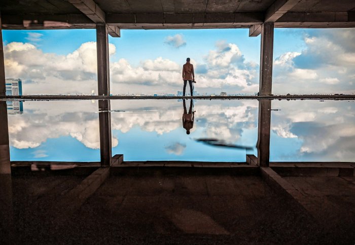 Man standing in unfinished building with water reflection
