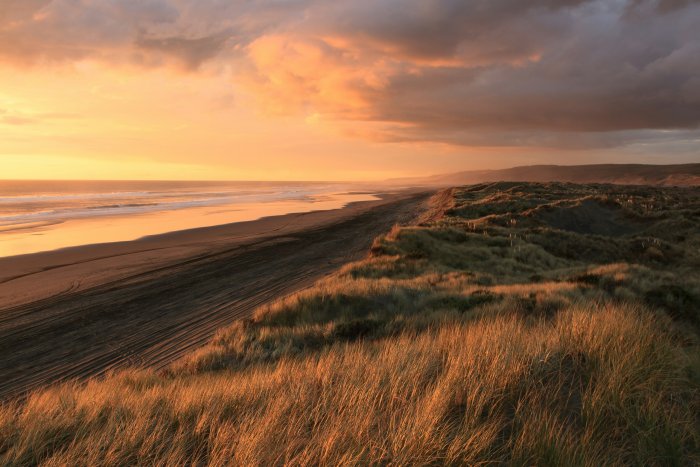 Cloudy sunset over coastal sand dunes and beach