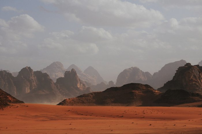 Red sand desert landscape with rocky mountains