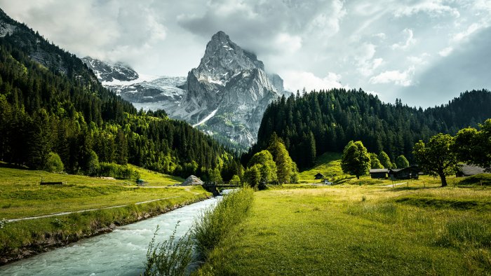Rocky mountain peak with river flowing through green valley